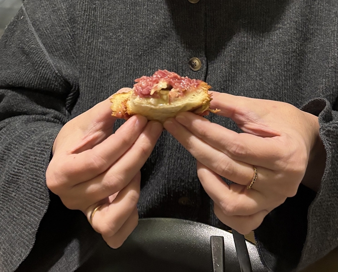 Dos manos agarrando un bocadillo de tartar de atun y mayones a kimchi, plano cerrado